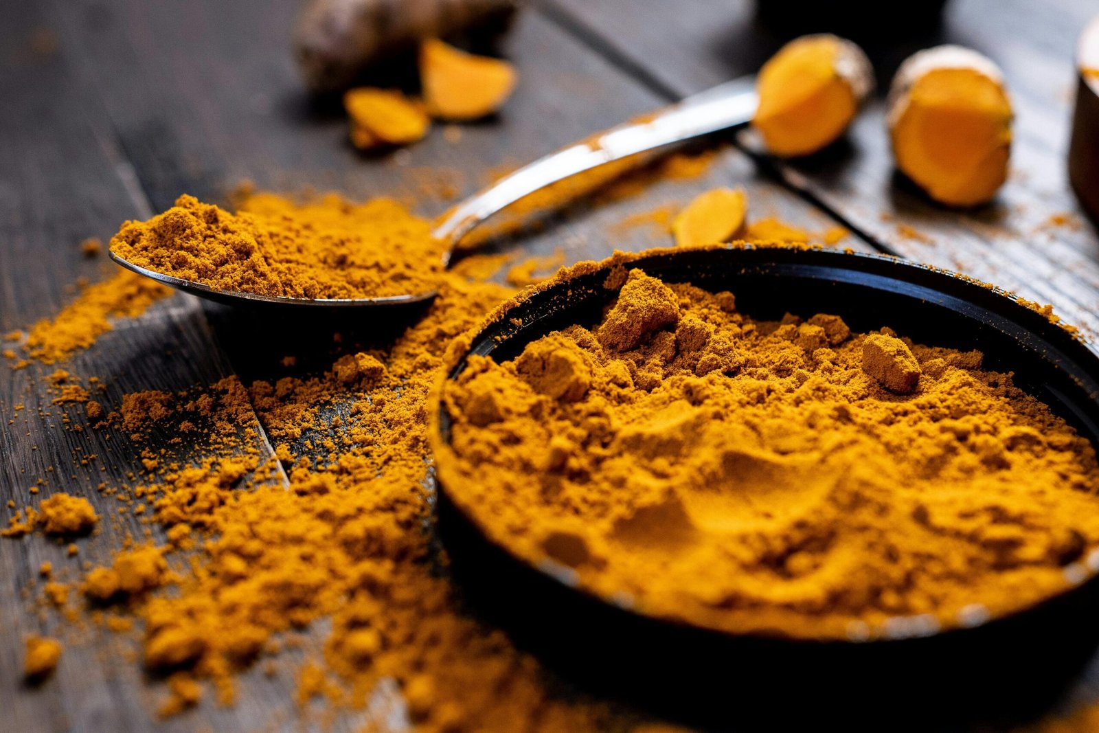 Close-up photo of turmeric powder, fresh ginger, and herbs used in Ayurvedic medicine