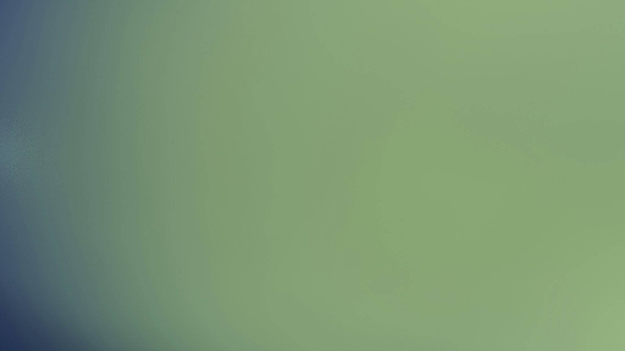 A woman smiling near a yoga mat holding a green smoothie bowl